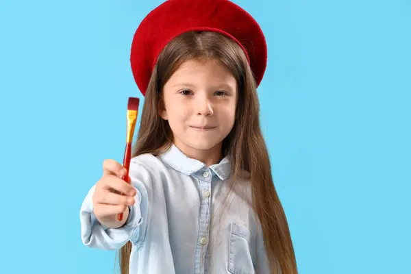 Stock image Cute little girl with paint brush on blue background