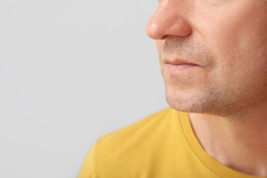 Gri arka planda olgun bir adam, yakın plan.