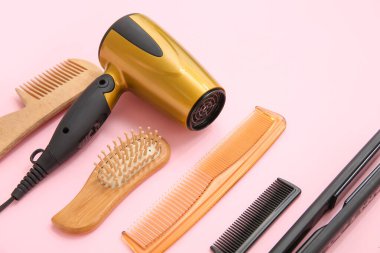 Pembe arka planda farklı kuaför aletleri