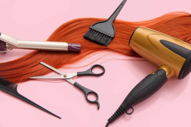 Pembe arka planda farklı kuaför aletleri