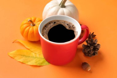 Bir fincan aromatik kahve ve arka planda güzel bir sonbahar dekoru olan kompozisyon.