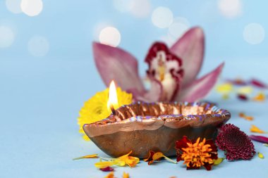 Mavi masada bulanık ışıklara karşı güzel çiçekli Diya lambası. Divaly kutlaması