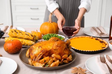 Yemek masasında lezzetli yemekleri olan bir kadın Şükran Günü için hazırlanıyor. Yakın plan.