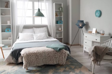 Yatak odasının içi büyük yatak ve lambalarla dolu.