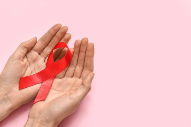 Woman with red ribbon on pink background. AIDS Day concept clipart