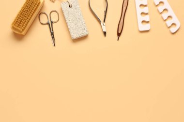 Turuncu arka planda pedikür için profesyonel araçlar