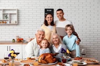 Şükran Günü 'nde mutlu bir aile şenlik masasında yemek yiyor.
