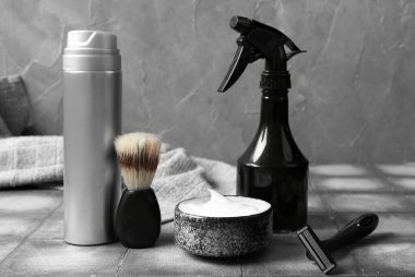 Gri duvarın yanındaki grunge fayansta tıraş aksesuarları.