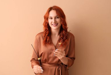 Havai fişekli genç kadın Noel 'i bej arka planda kutluyor