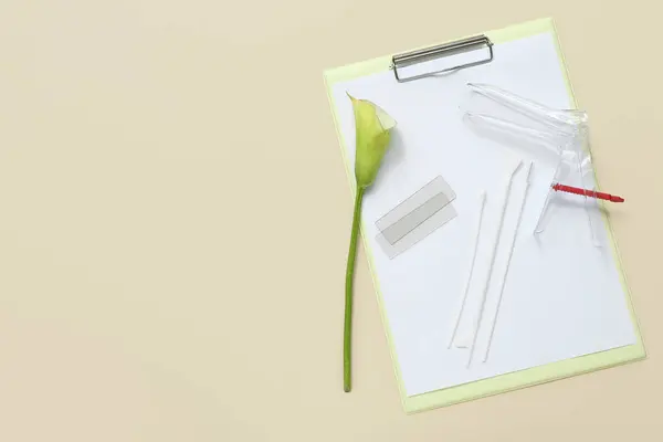 Gynecological speculum with pap smear test tools and clipboard on light background