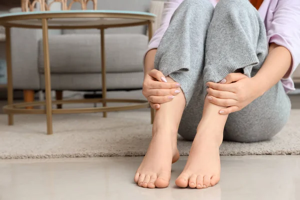 Barefoot woman with floor heating at home, closeup
