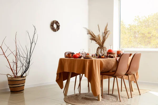 Autumn table setting with pumpkins and pampas grass in light living room
