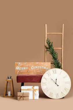 Noel dekorlu yumuşak bank, hediyeler, kahverengi arka planda saat ve merdiven