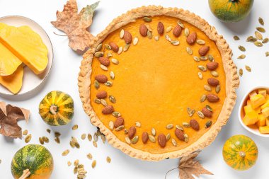 Bademli balkabaklı tart ve beyaz arka planda tohumlar.