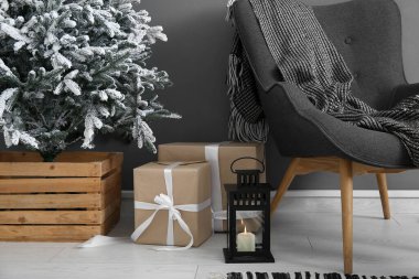 Koltuk, fener, hediye kutuları ve oturma odasında Noel ağacı, yakın plan.
