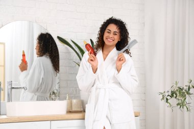 Saç spreyi ve banyoda tarağı olan güzel bir Afro-Amerikalı kadın.
