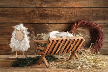 Ahşap arka planda bebek ve koyun kuklası olan ahır. Noel hikayesi kavramı