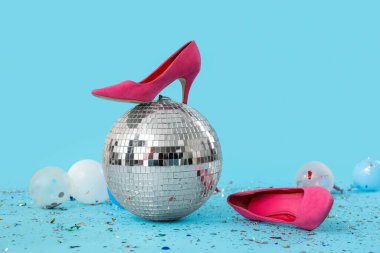 Topuklu disko topu ve mavi arka planda konfeti.