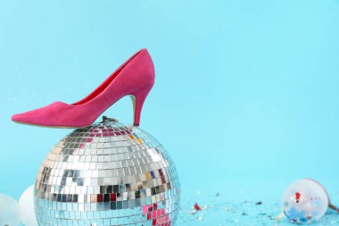 Topuklu disko topu ve mavi arka planda konfeti.