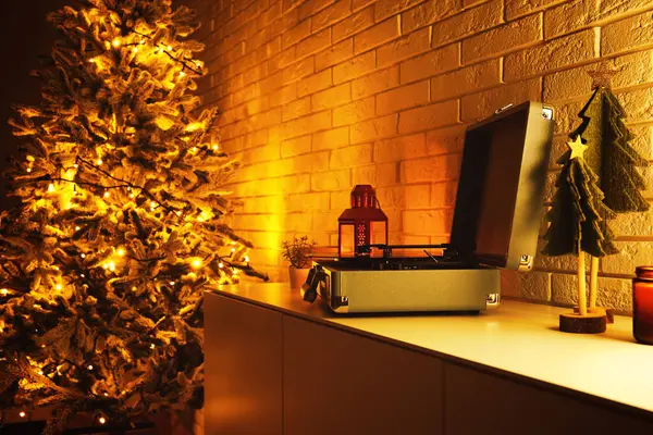Record player on cabinet in festive living room at evening, closeup