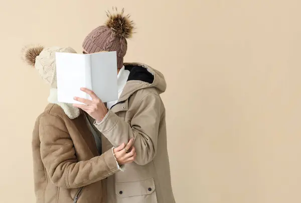 Liebespaar Winterkleidung Mit Buch Auf Beigem Hintergrund — Stockfoto