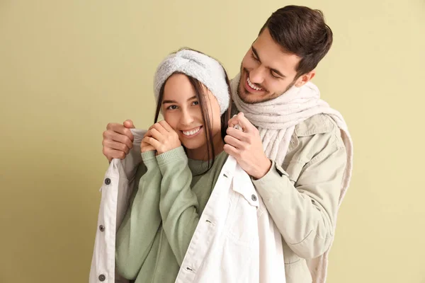 Young Man Putting Jacket His Frozen Girlfriend Green Background — Stock Photo, Image