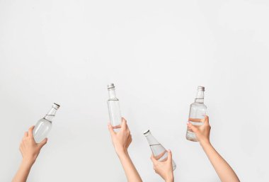 Arka planda temiz su şişeleri olan kadın eller.