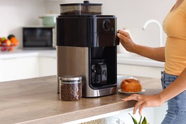 Mutfakta kahve yapan genç bir kadın, yakın plan.