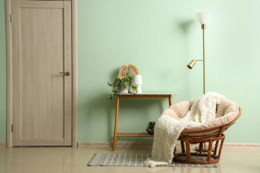 Oturma odasının içinde koltuk, masa ve lamba var.