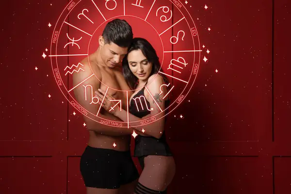 Tutkulu genç bir çift ve kırmızı arka planda Zodiac tekerleği. Cinsel uyumluluk yıldız falı