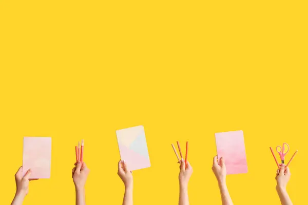 stock image Hands with school supplies on yellow background