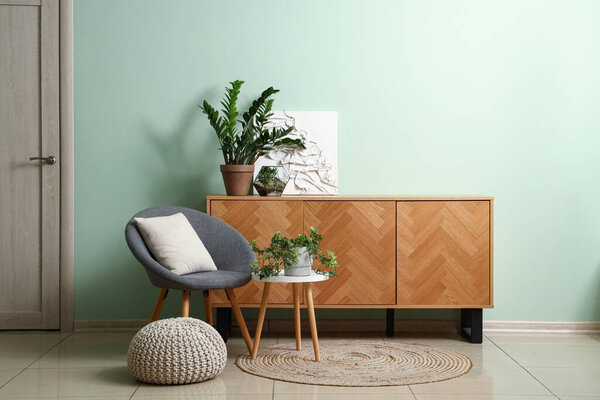 Interior of living room with armchair, table and drawers