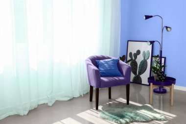 Oturma odasının içinde şık mobilyalarla aydınlık perdeler.