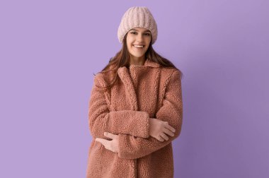 Leylak arkaplanda oyuncak ceketli genç bir kadın.