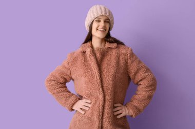 Leylak arkaplanda oyuncak ceketli genç bir kadın.