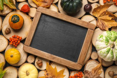 Tahta, balkabağı ve sonbahar yapraklarıyla ahşap dilimler üzerine kompozisyon