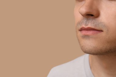 Kahverengi arka plandaki hasta genç adam, yakın plan.