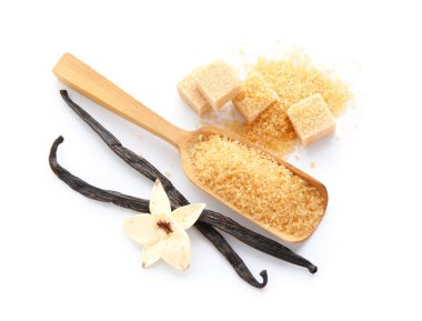 Aromatik vanilya şekerli kaşık, çiçek ve beyaz arka planda çubuklar