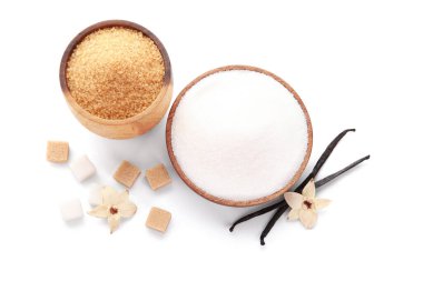 Aromatik vanilya şekerli kaseler, çiçekler ve beyaz arka planda çubuklar