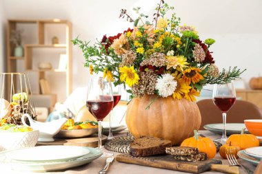 Şenlikli yemek masasında sonbahar çiçekli balkabağı, yakın plan.