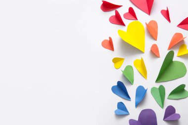 Beyaz arka planda kağıttan yapılmış renkli kalpler. LGBT kavramı