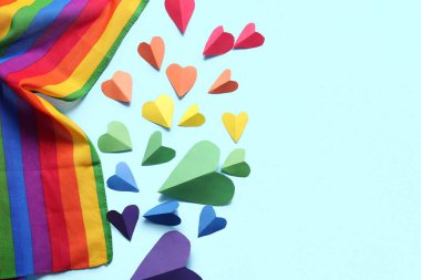 Renkli kağıt kalpler ve mavi arka planda LGBT bayrağı. LGBT kavramı