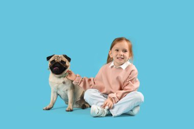 Mavi arka planda sevimli pug köpekli küçük kız