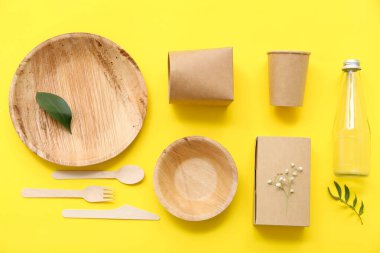 Sarı arkaplanda yaprakları olan tek kullanımlık eko tablo takımı