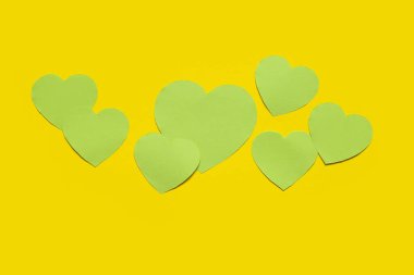 Sarı arka planda yeşil kağıt kalpler. Sevgililer Günü kutlaması