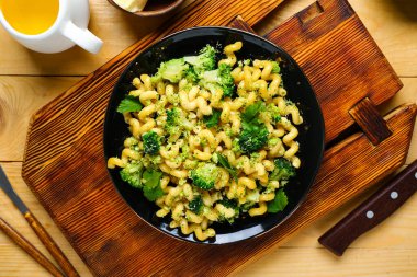 Tahta zemin üzerinde brokoli olan lezzetli bir makarna tabağı.