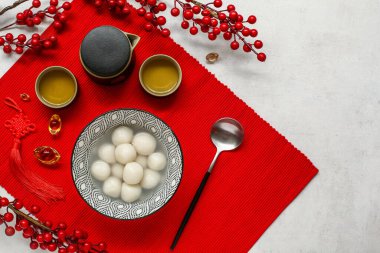 Kırmızı hasırlı, bir kase tangyuan, çay ve beyaz grunge arka planda Çin dekoru. Dongzhi Festivali