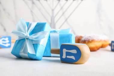 Işık masasında Hanuka kutlaması için hediye kutuları ve eşyalar.