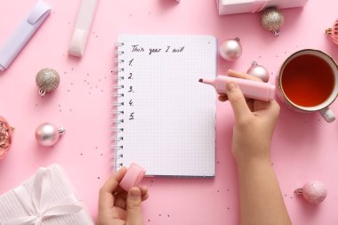 Bu Yılı Yazan Kadın Pembe arka planda Not Defterine ve Noel Dekorasyonuna Yazacağım
