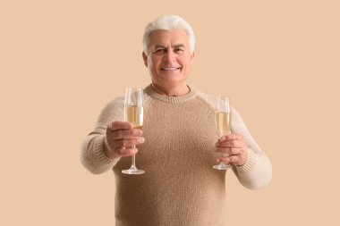 Bej arka planda Noel 'i kutlayan şampanya kadehli son sınıf öğrencisi.